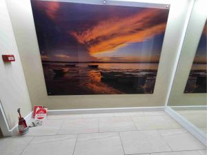 printed image on wall, boats and sunset by low tide